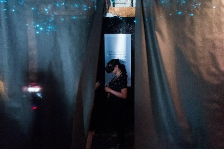 women playing manic vr behind curtain
